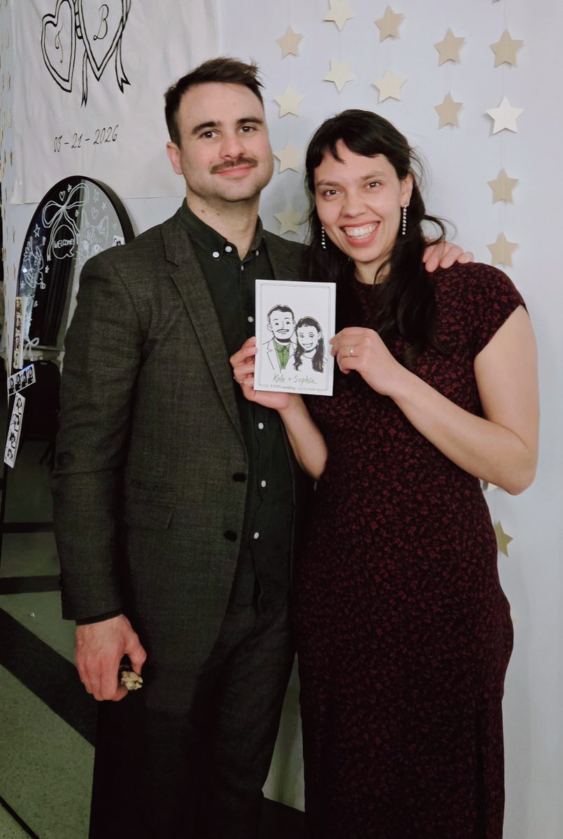 Guests holding personalized live sketch portraits